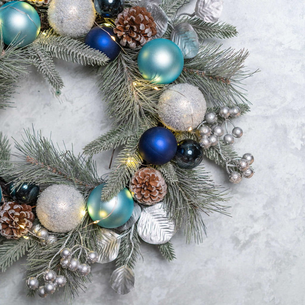 YULETIME 20-inch Christmas Wreath, Battery Operated Holiday Wreath with 20 Fairy Lights, Blue Baubles, Silvery Berries, Pine Cones, Silvery Leaves, Frosted Spruce Branches and Pine Needles (Blue)